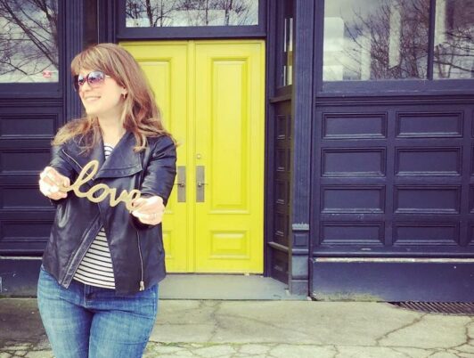 rochelle bergstrom holding a sign that says love