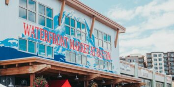 A Sign painted in Red and Blue on the side of a building in Tacoma's Point Ruston reads 
