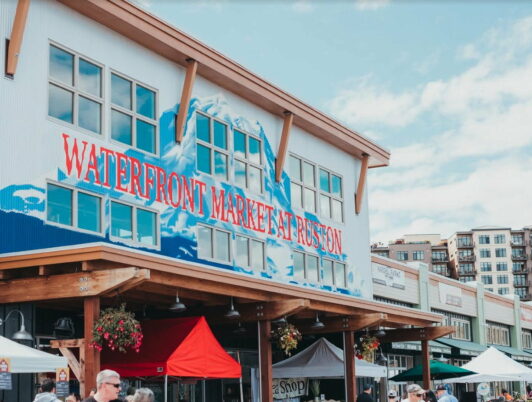 A Sign painted in Red and Blue on the side of a building in Tacoma's Point Ruston reads 