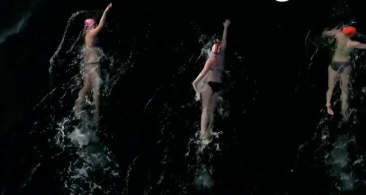 three people swimming in the puget sound in tacoma washington with the move to tacoma logo in the corner